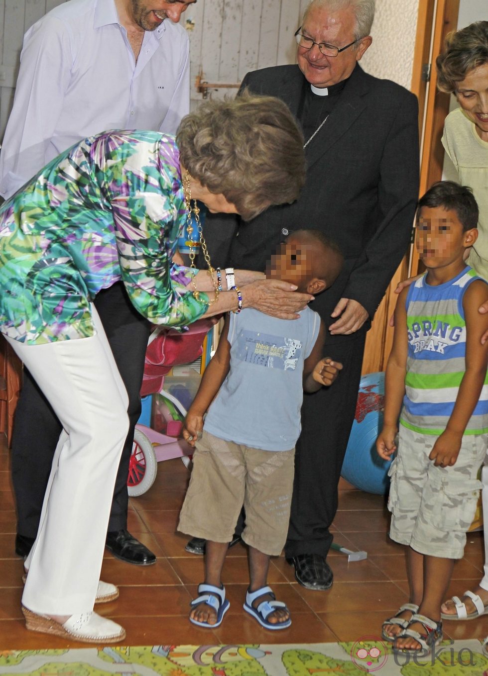 La Reina Sofía acaricia a un niño durante su visita a los proyectos de Cáritas Mallorca