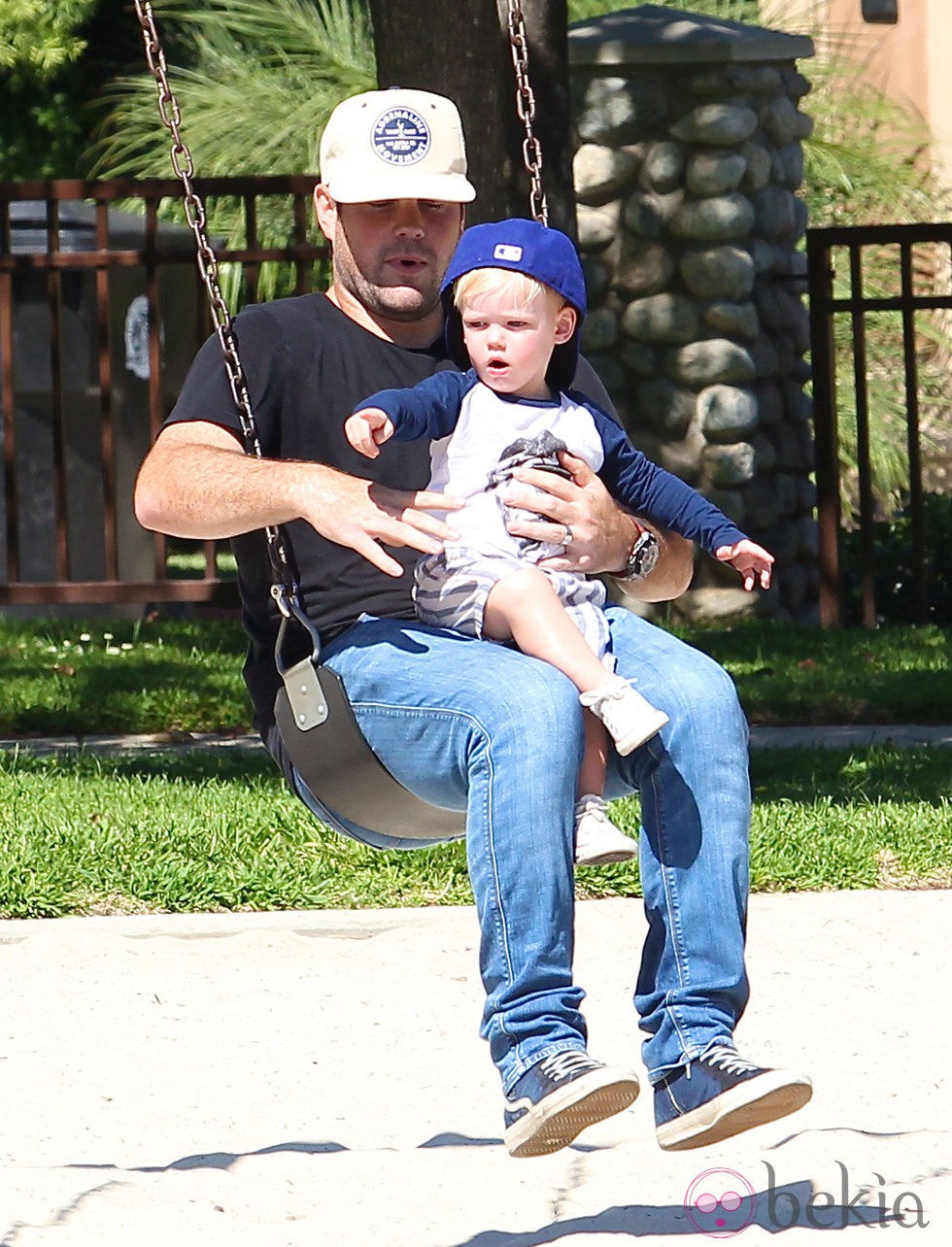 Mike Comrie con su hijo Luca en brazos en un parque de Beverly Hills
