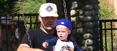 Mike Comrie con su hijo Luca en brazos en un parque de Beverly Hills