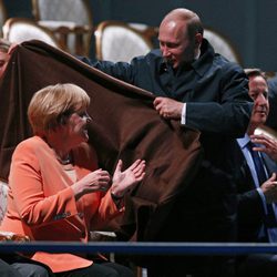 Vladimir Putin cubriendo a Angela Merkel con una manta en San Petersburgo