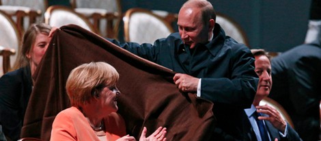 Vladimir Putin cubriendo a Angela Merkel con una manta en San Petersburgo