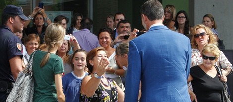 Los Príncipes de Asturias saludan a unas señoras tras visitar al Rey en el hospital