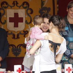 La Princesa de Asturias, cariñosa con un bebé en el Día de la Banderita 2013