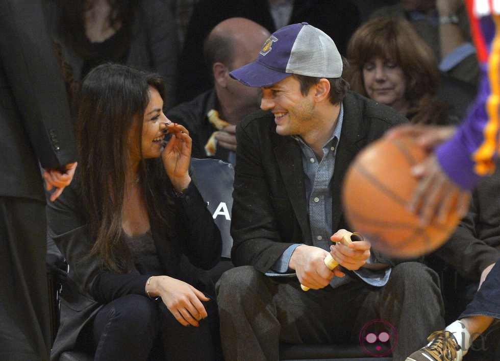 Mila Kunis y Ashton Kutcher se divierten durante un partido de Los Angeles Lakers