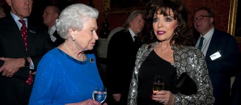 La Reina Isabel charla con Joan Collins en una recepción en Buckingham Palace