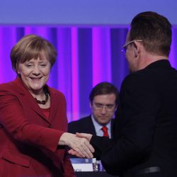 Bono saluda a Angela Merkel durante su intervención en el congreso del Partido Popular Europeo en Dublín