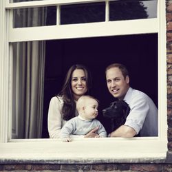 El Príncipe Guillermo y Kate Middleton posan con el Príncipe Jorge y un perro desde una ventana del Palacio de Kensington