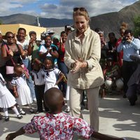 La Infanta Elena aplaude a un niño durante su viaje a Ecuador