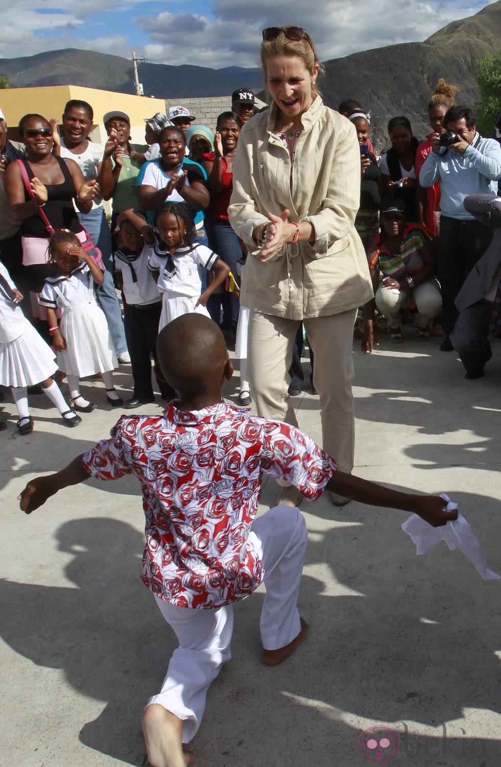 La Infanta Elena aplaude a un niño durante su viaje a Ecuador
