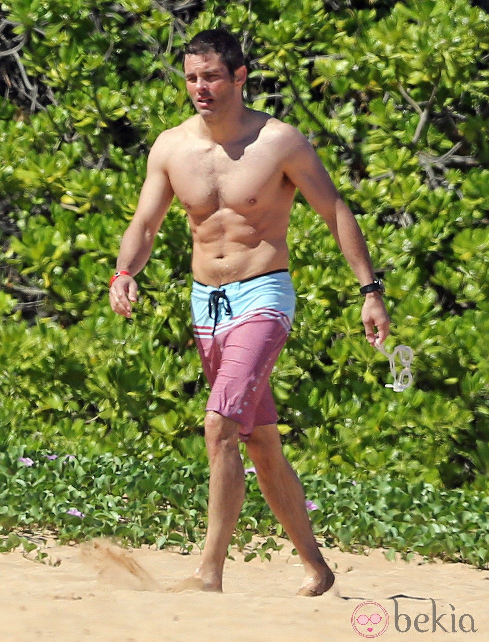 James Marsden en bañador caminando por una playa de Hawaii