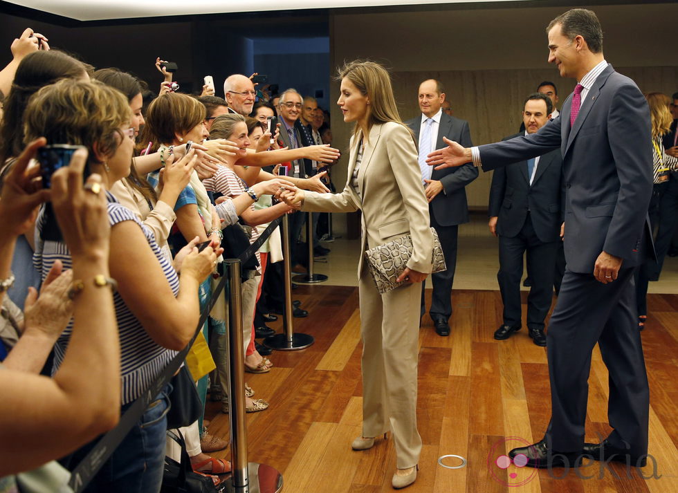Los Príncipes Felipe y Letizia saludan a unos ciudadanos en la inauguración de una exposición
