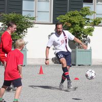 Haakon de Noruega jugando al fútbol en un partido amistoso