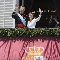 El Rey Felipe VI y la Reina Letizia saludan al pueblo desde el balcón central del Palacio Real