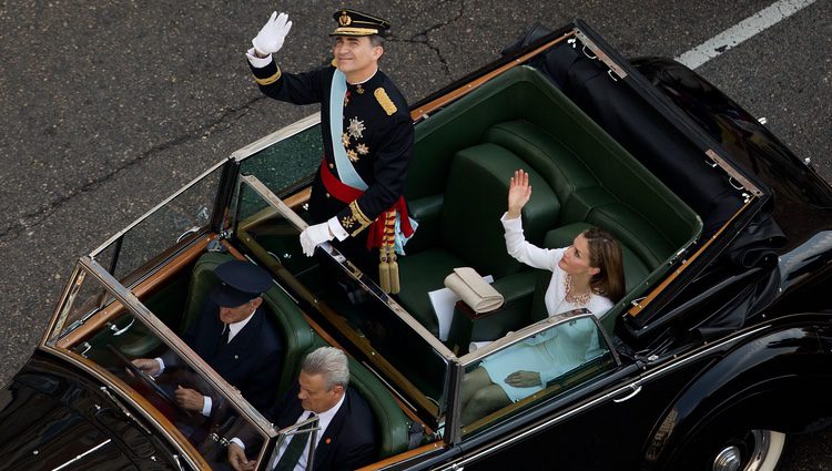 El Rey Felipe VI y la Reina Letizia saludan durante el paseo oficial por el centro de Madrid