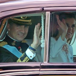 El Rey Felipe VI y la Reina Letizia saludan durante el recorrido hasta el Congreso de los Diputados