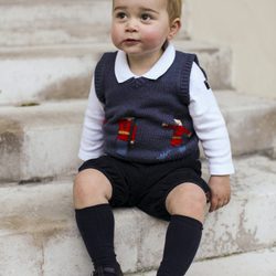 El Príncipe Jorge, sentado en las escaleras del Palacio de Kensington