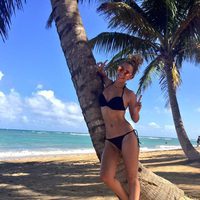 Edurne luce cuerpo en bikini en la playa junto a una palmera