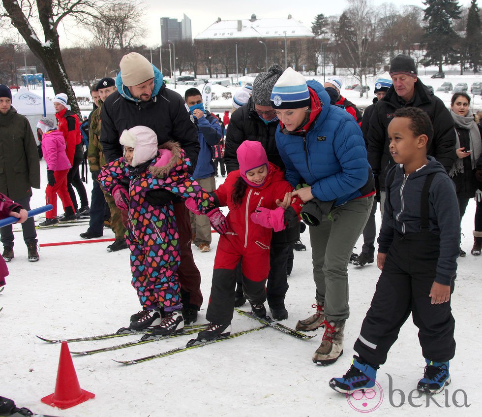 Haakon y Mette-Marit de Noruega ayudan a unos niños a esquiar