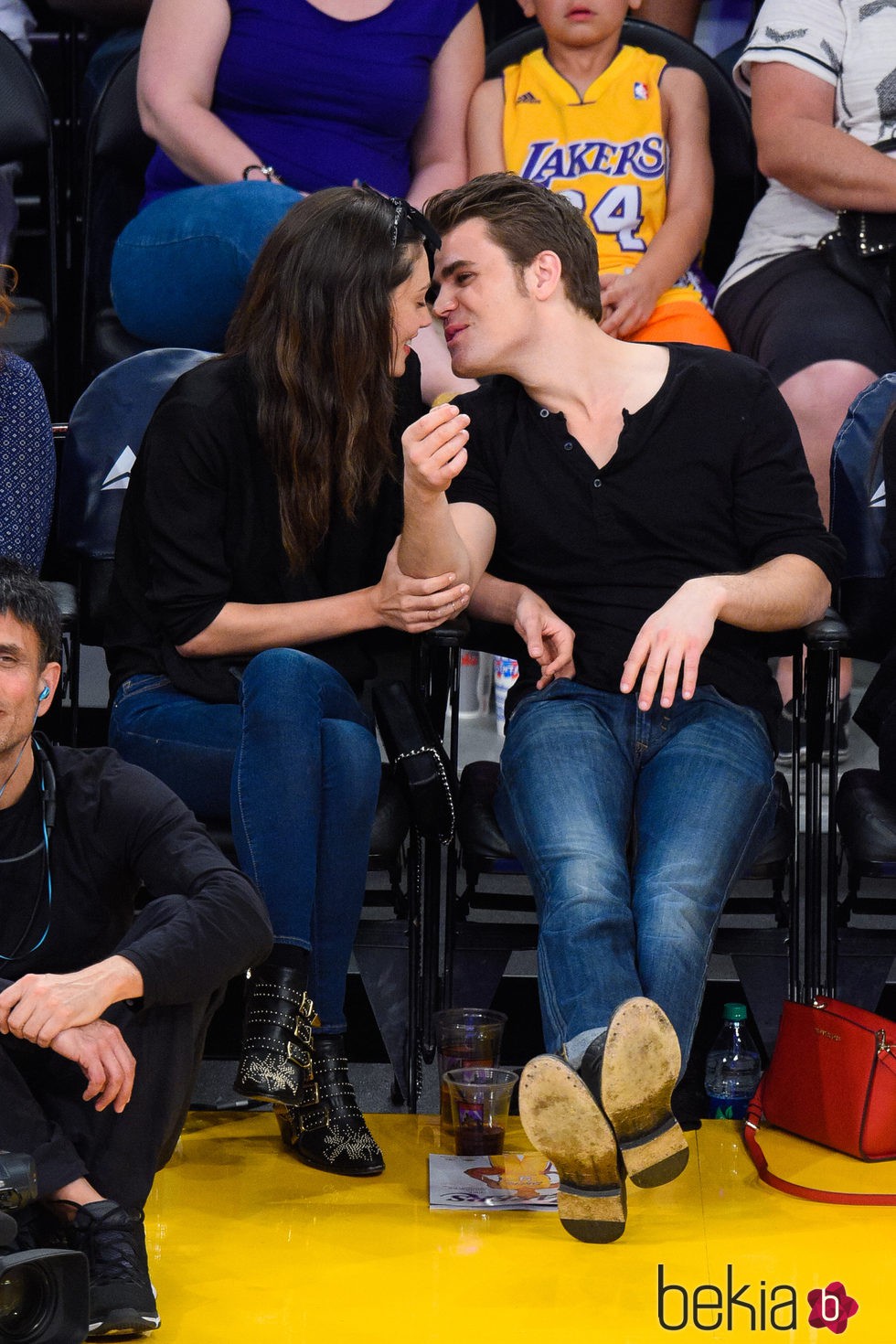 Phoebe Tonkin y Paul Wesley besándose en un partido de Los Lakers