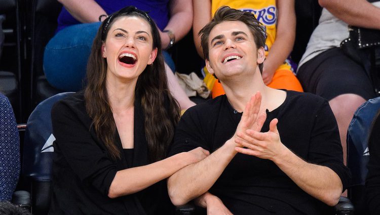Phoebe Tonkin y Paul Wesley riéndose en un partido de Los Lakers