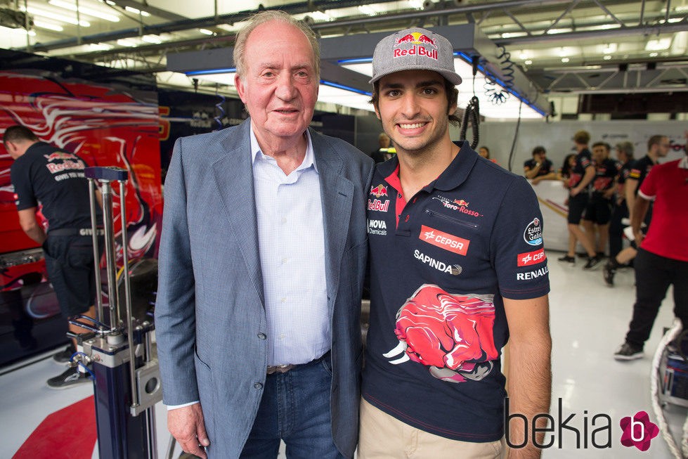 El Rey Juan Carlos posa junto a Carlos Sainz hijo que se estrena en Toro Rosso
