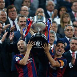 Andrés Iniesta y Xavi Hernández levantan la Copa del Rey ante la mirada del Rey Felipe VI