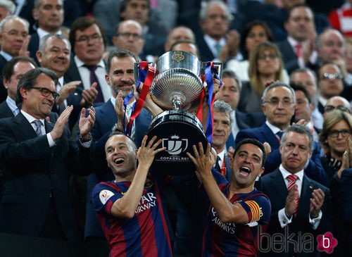 Andrés Iniesta y Xavi Hernández levantan la Copa del Rey ante la mirada del Rey Felipe VI
