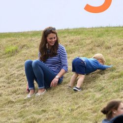 El Príncipe Jorge de Cambridge jugando en el césped junto a Kate Middleton