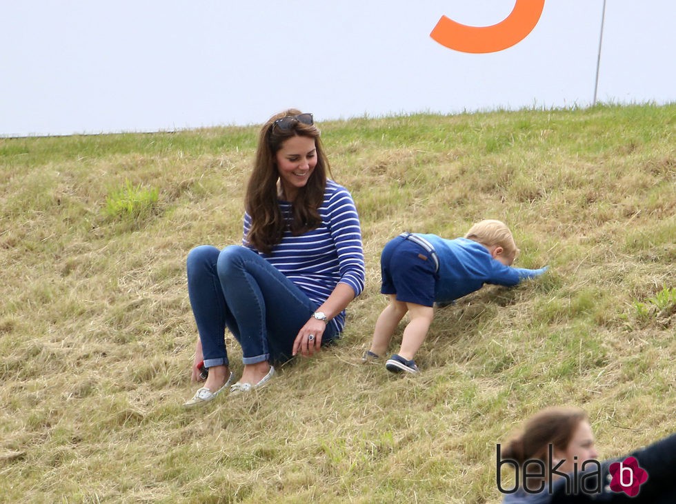 El Príncipe Jorge de Cambridge jugando en el césped junto a Kate Middleton