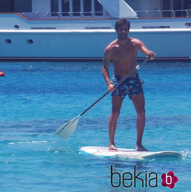 El novio de Irene Carbonero con el torso desnudo practicando paddle surf