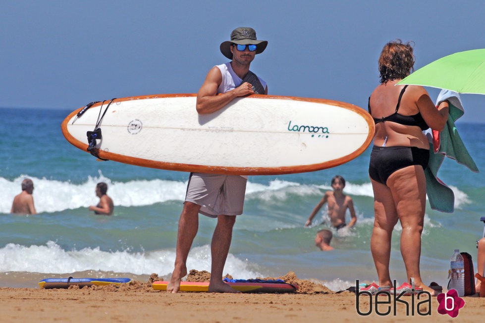 Hugo Silva con una tabla de surf en Cádiz