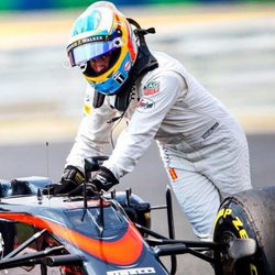 Fernando Alonso empujando su monoplaza tras una avería en el GP de Hungría 2015