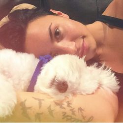 Demi Lovato junto a su perro Buddy tumbados