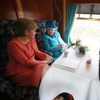 La Reina Isabel y el Duque de Edimburgo con la Primera Ministra de Escocia en un tren
