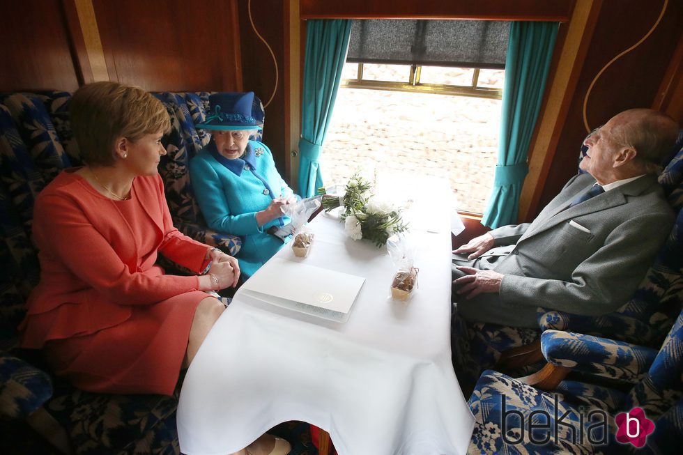 La Reina Isabel y el Duque de Edimburgo con la Primera Ministra de Escocia en un tren