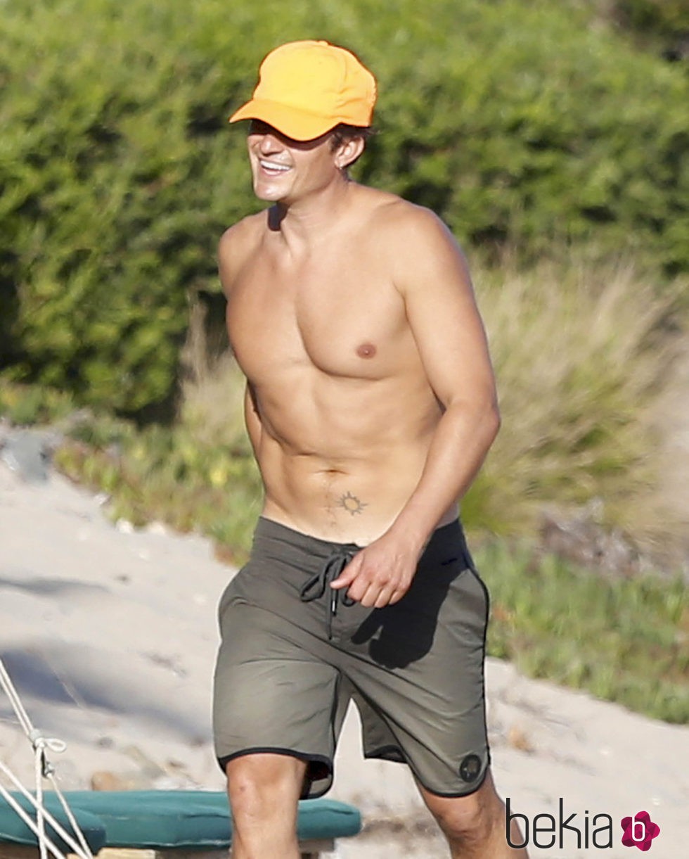 Orlando Bloom con el torso desnudo paseando por la playa
