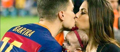 Marc Bartra y Melissa Jiménez se dan un beso junto a su hija Gala en el Camp Nou