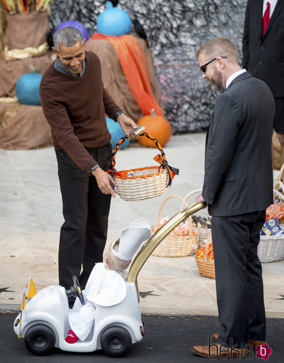Barack Obama dando dulces por Halloween 2015 a un niño disfrazado de Papa