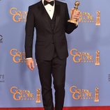 Jon Hamm posando con su premio de los Globos de Oro 2016