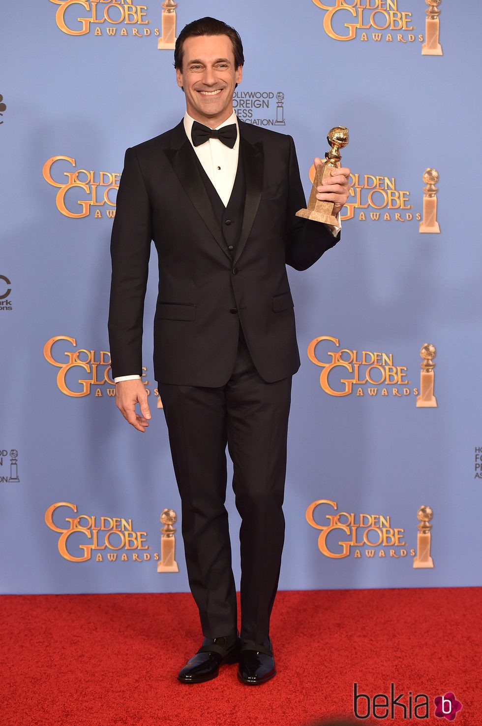Jon Hamm posando con su premio de los Globos de Oro 2016