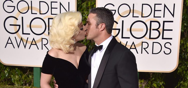 Lady Gaga y Taylor Kinney besándose en la alfombra roja de los Globos de Oro 2016