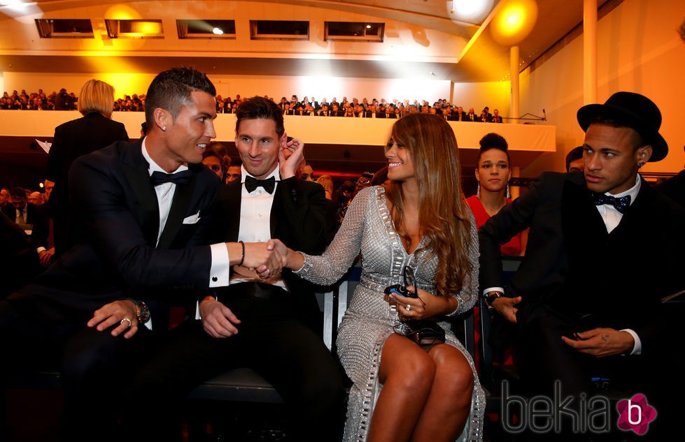Cristiano Ronaldo y Antonella Roccuzzo se saludan ante la mirada de Leo Messi en la entrega del Balón de Oro 2015