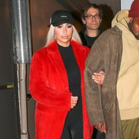 Kim Kardashian con un jumpsuit negro con un abrigo rojo