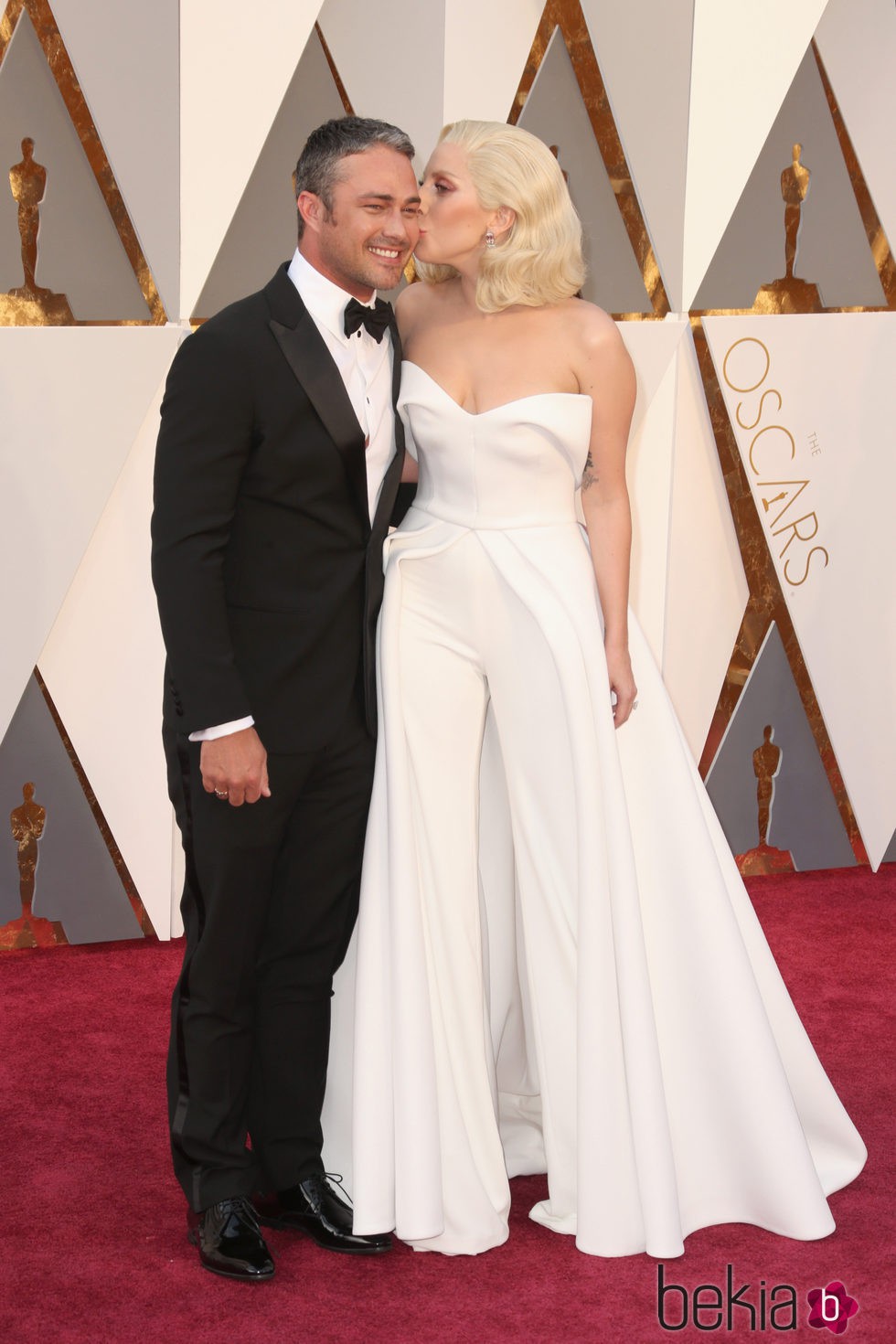 Lady Gaga besando a su prometido Taylor Kinney en la alfombra roja en los Premios Oscar 2016