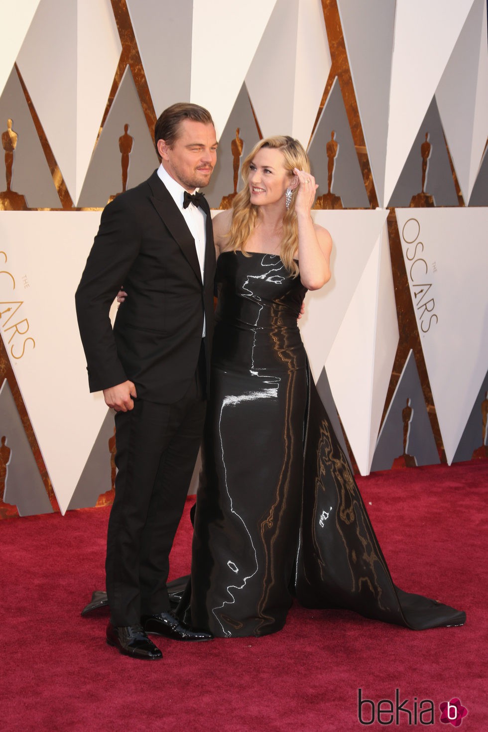 Kate Winslet observa de forma cariñosa a Leonardo DiCaprio en la alfombra roja de los Premios Oscar 2016