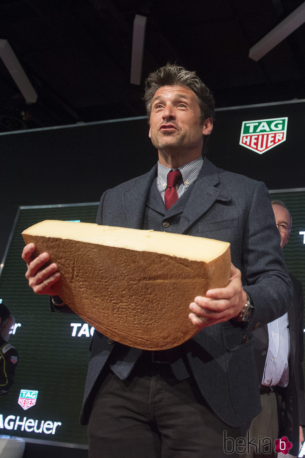 Patrick Dempsey en el Salón Internacional del Automóvil de Ginebra cargando con medio queso