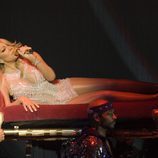 Mariah Carey cantando tumbada en un divan durante un concierto en Glasgow