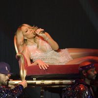 Mariah Carey cantando tumbada en un divan durante un concierto en Glasgow