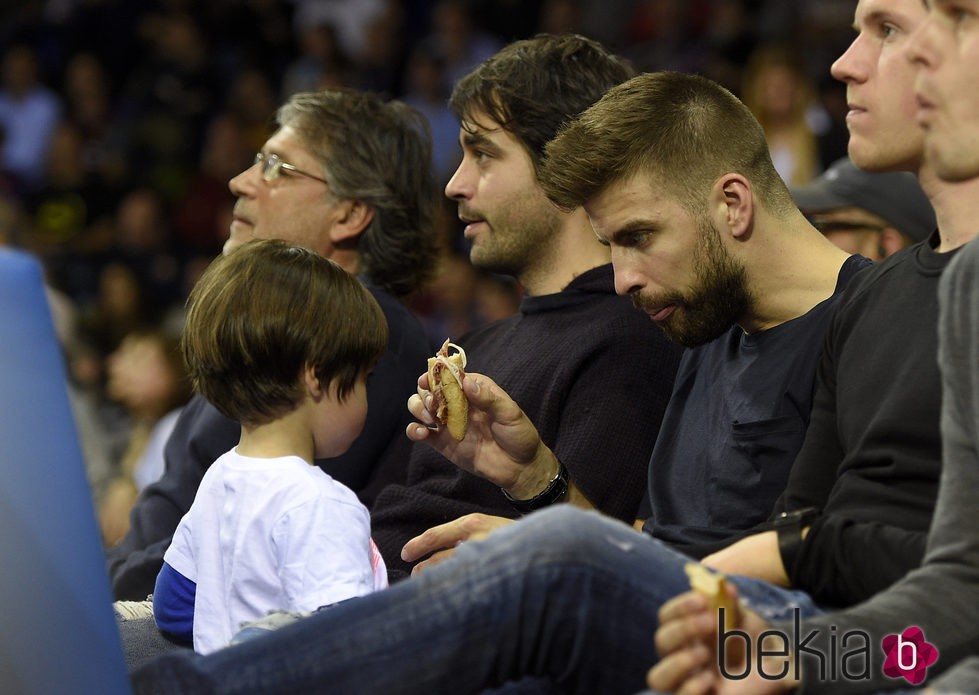 Gerard Piqué da la merienda a su hijo Milan en un partido de baloncesto