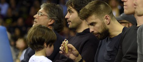 Gerard Piqué da la merienda a su hijo Milan en un partido de baloncesto